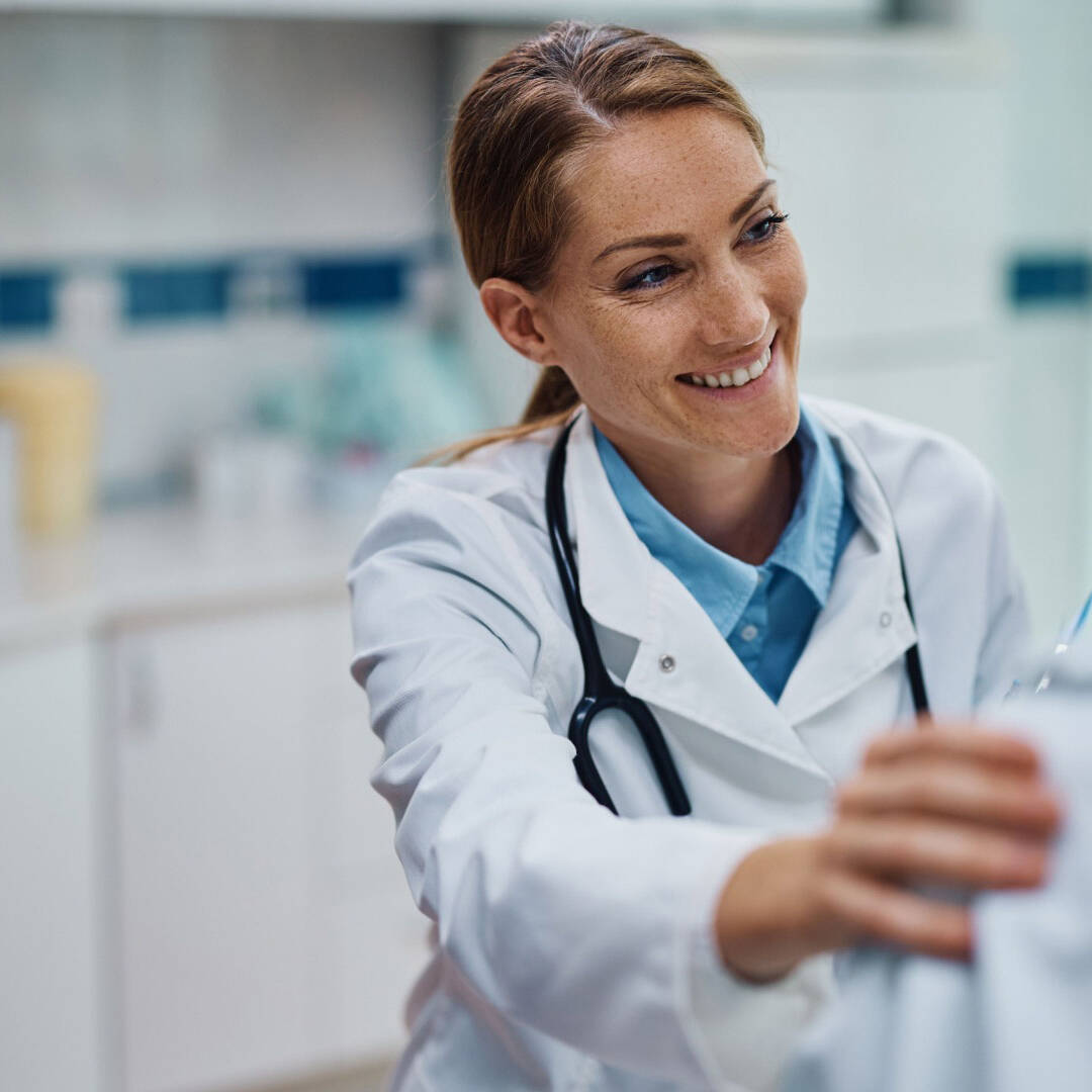 Doctor smiling, with hand on patient's shoulder